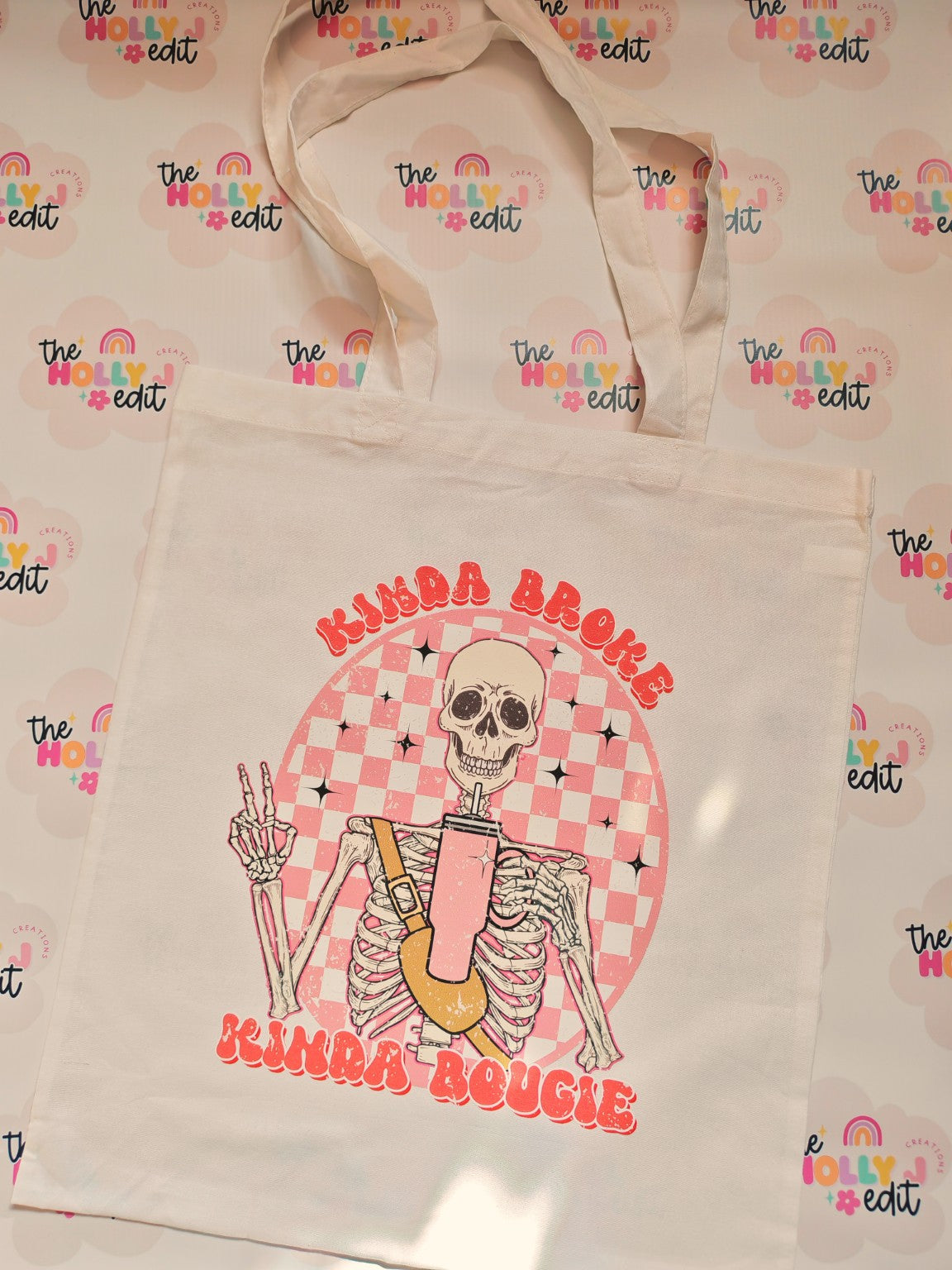 White cotton tote bag with pink skeleton and checkerboard design
