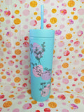 Blue 16oz skinny tumbler with pink Easter egg and floral design, with straw