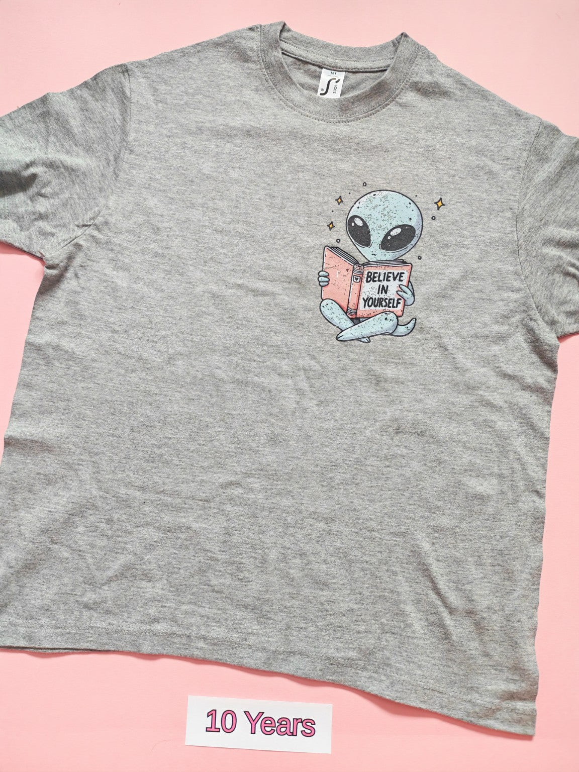 Grey children's T-shirt with cute alien reading Believe In Yourself book design, size 10 years