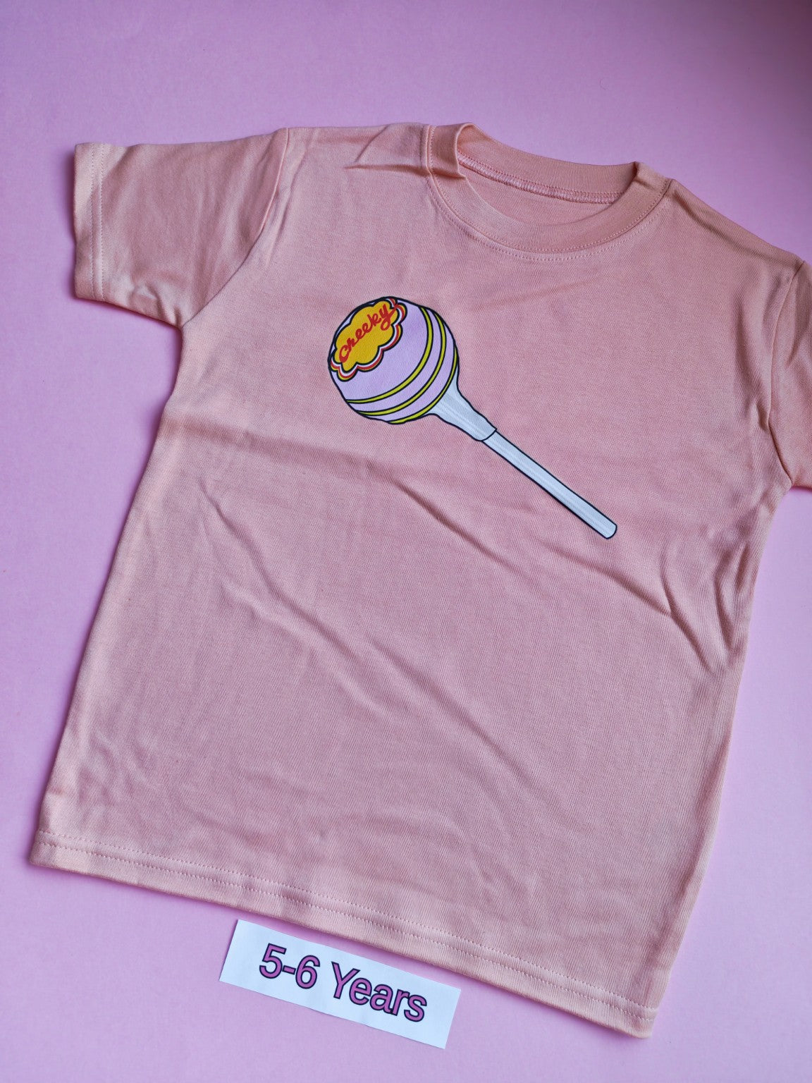 Peach children's t-shirt with colourful cheeky lollipop design, 5-6 years