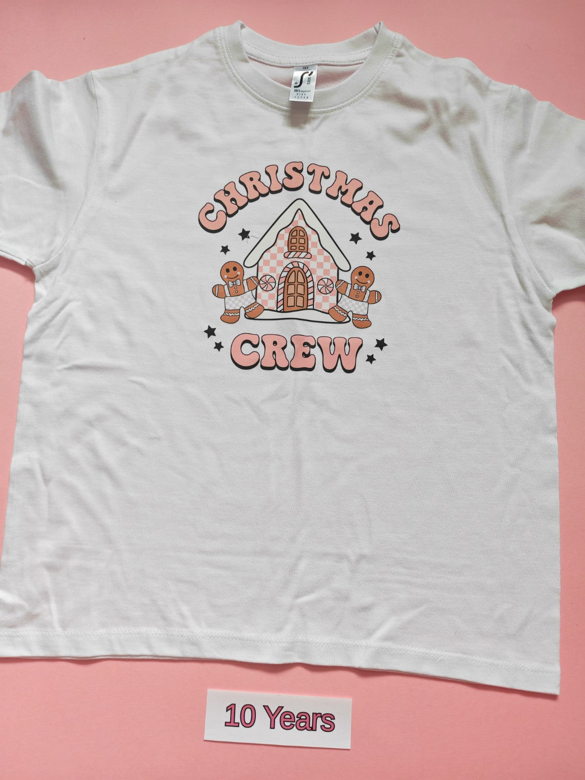 White children's Christmas T-shirt with Christmas Crew gingerbread house design, size 10 years