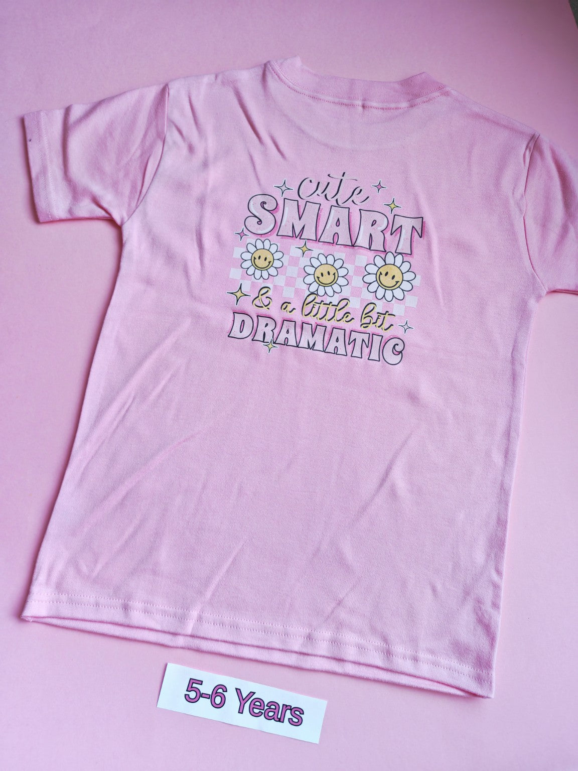 Pink children's t-shirt with Cute Smart and a Little Bit Dramatic daisy design on the back, 5-6 years