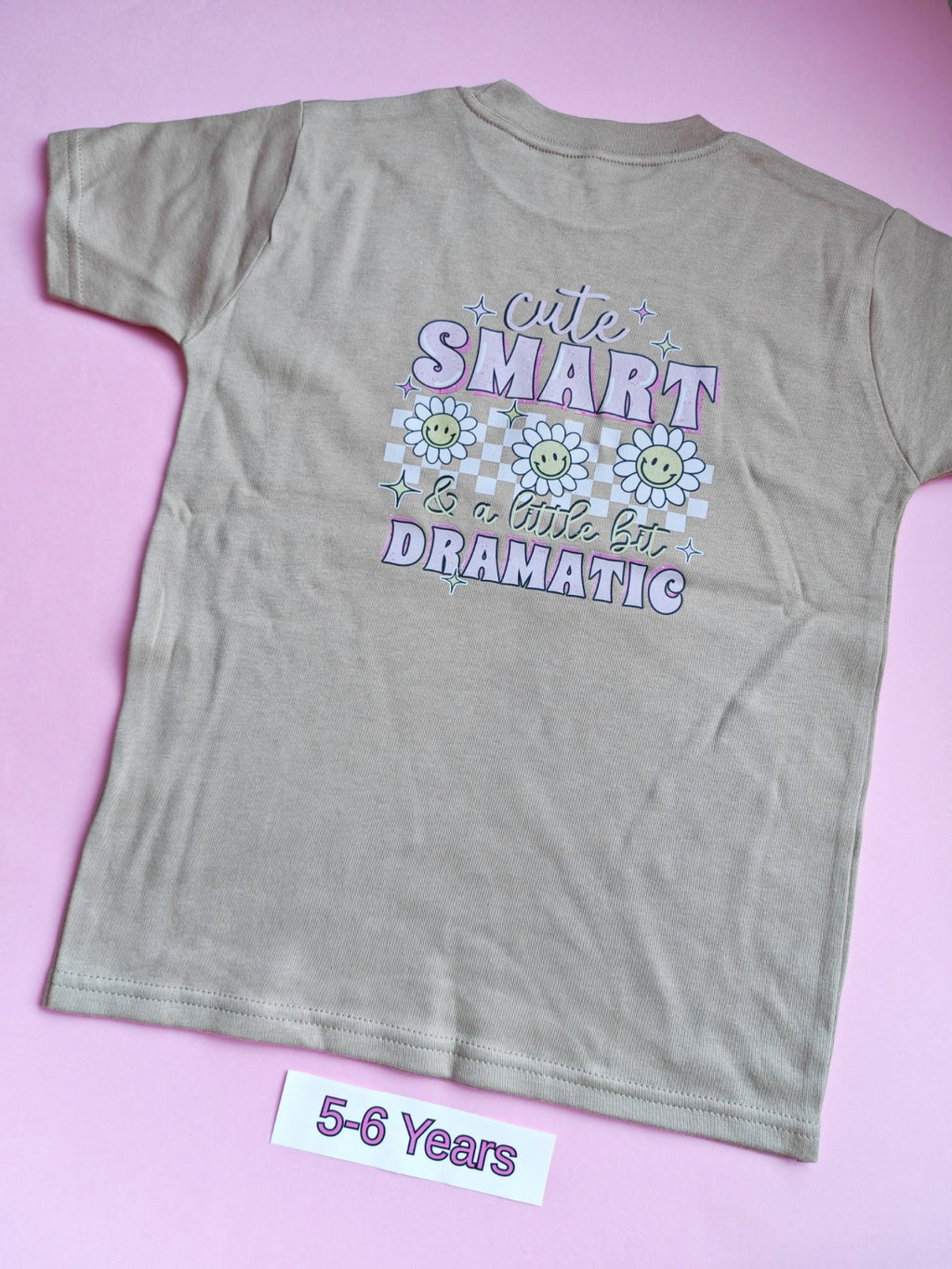 Taupe children's t-shirt with Cute Smart and a Little Bit Dramatic daisy design on the back, 5-6 years