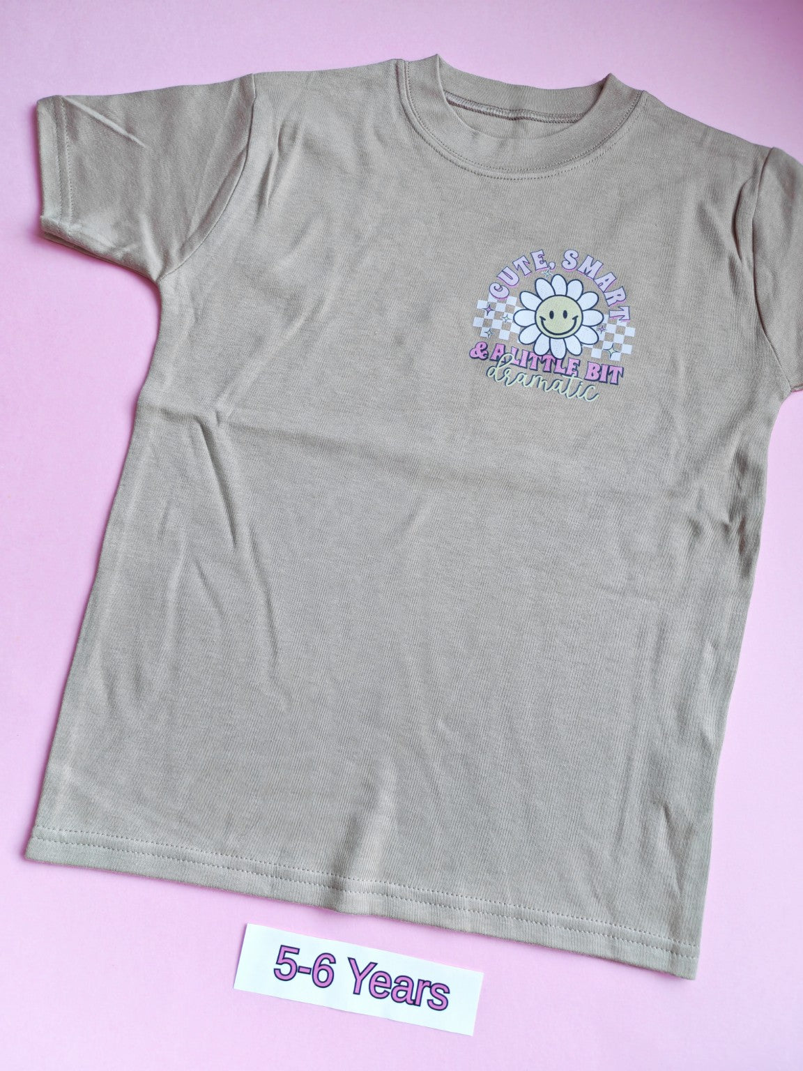 Taupe children's t-shirt with cute smart and a little bit dramatic daisy design, 5-6 years, front