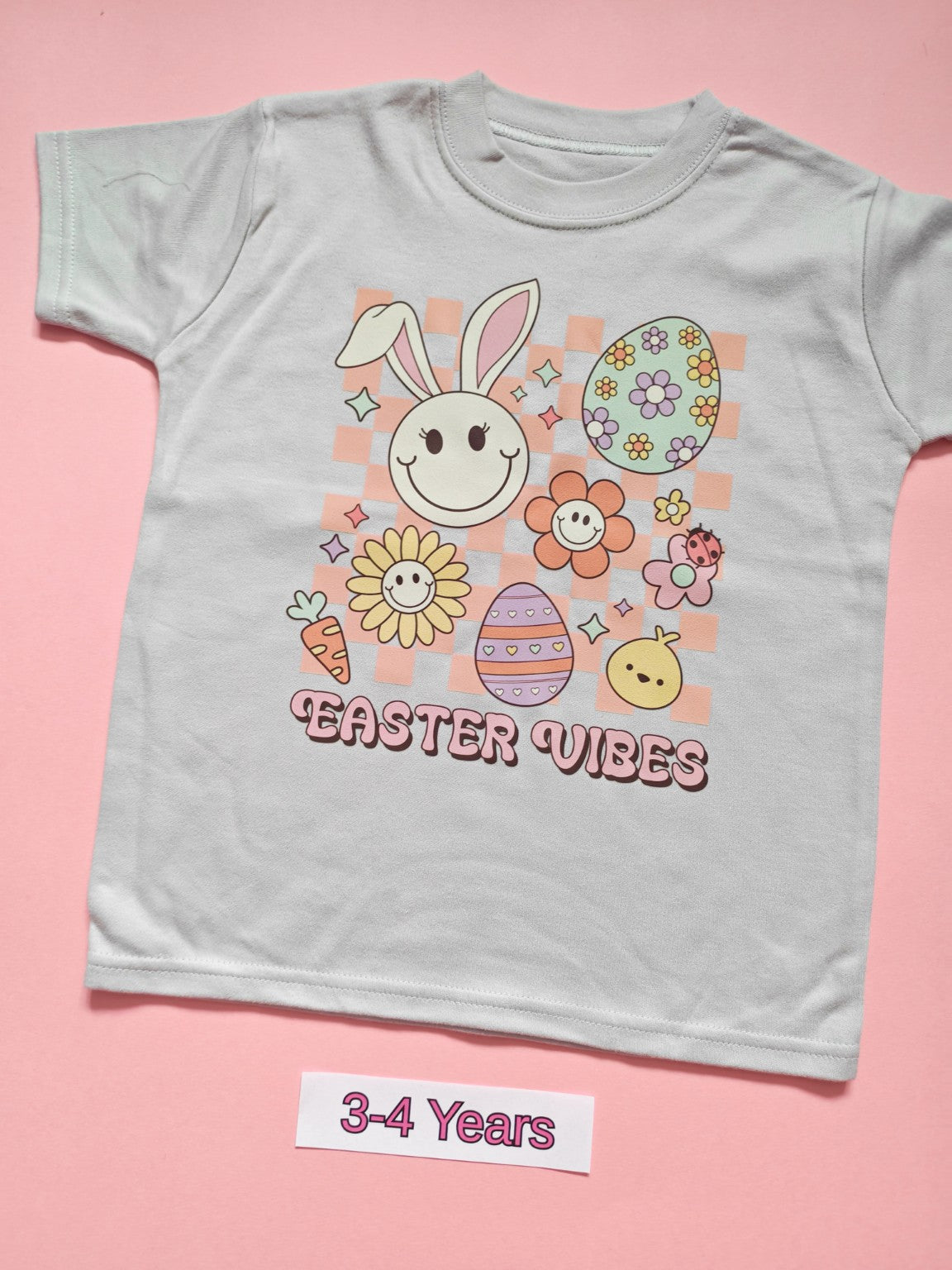 White children's T-shirt with pastel Easter Vibes bunny, flowers and Easter egg design, size 3-4 years