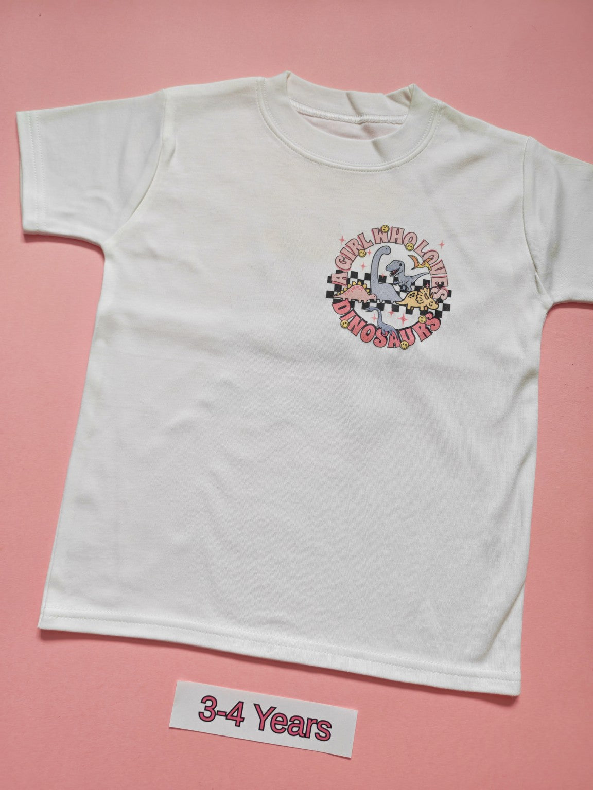 White children's T-shirt with pink dinosaur Girl Who Loves Dinosaurs design, size 3-4 years, front