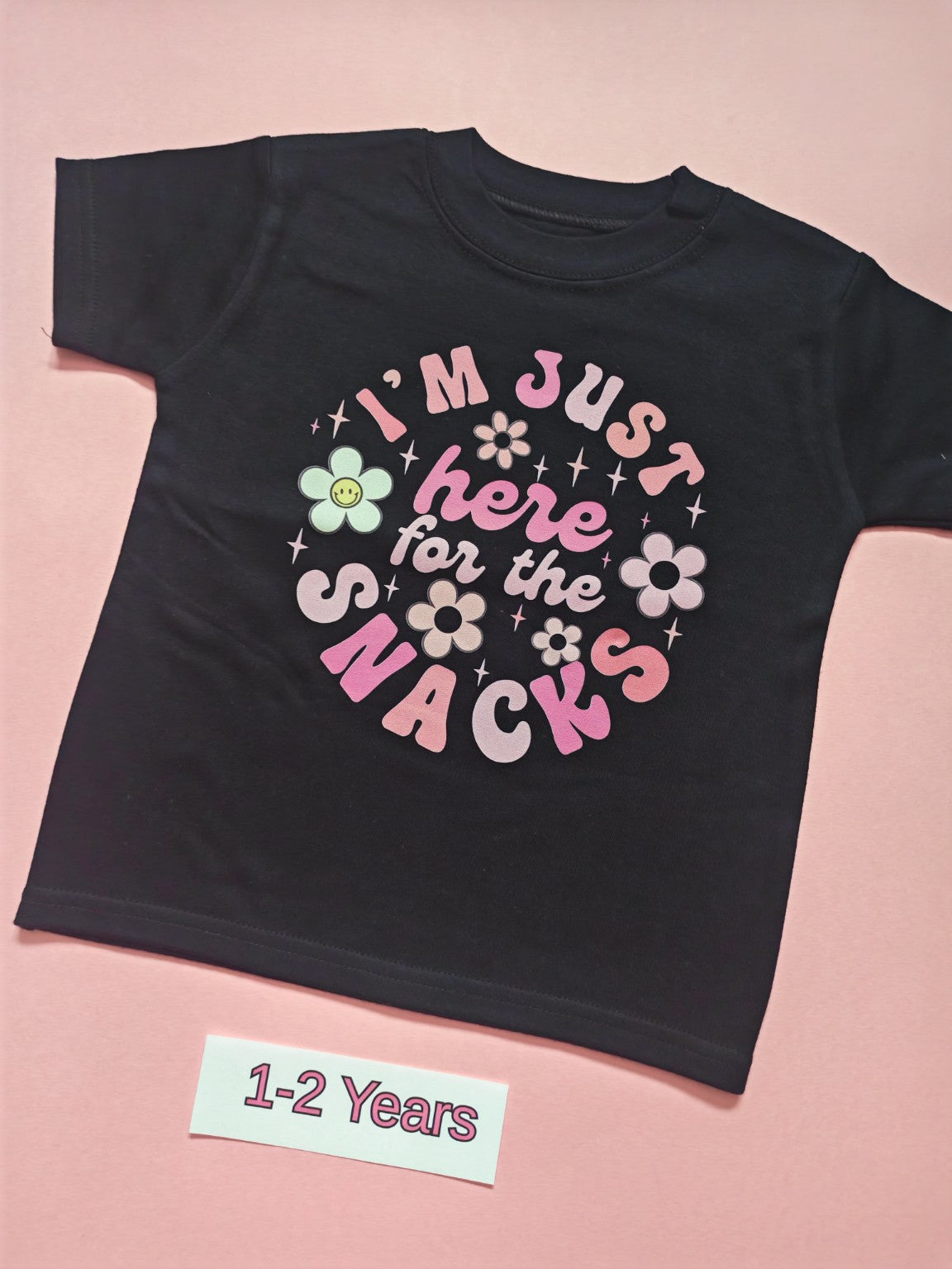 Black children's T-shirt with colourful flowers and I'm just here for the snacks slogan, size 1-2 years