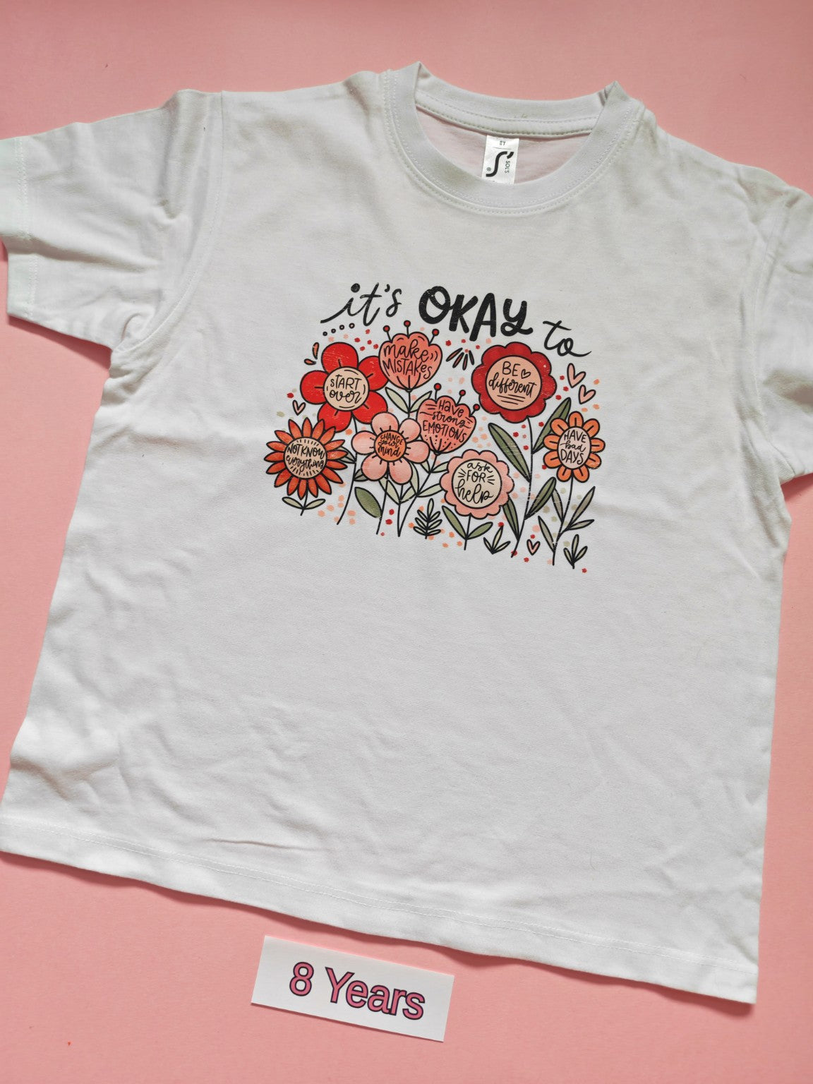 White children's T-shirt with It's Okay floral positive message design, size 8 years