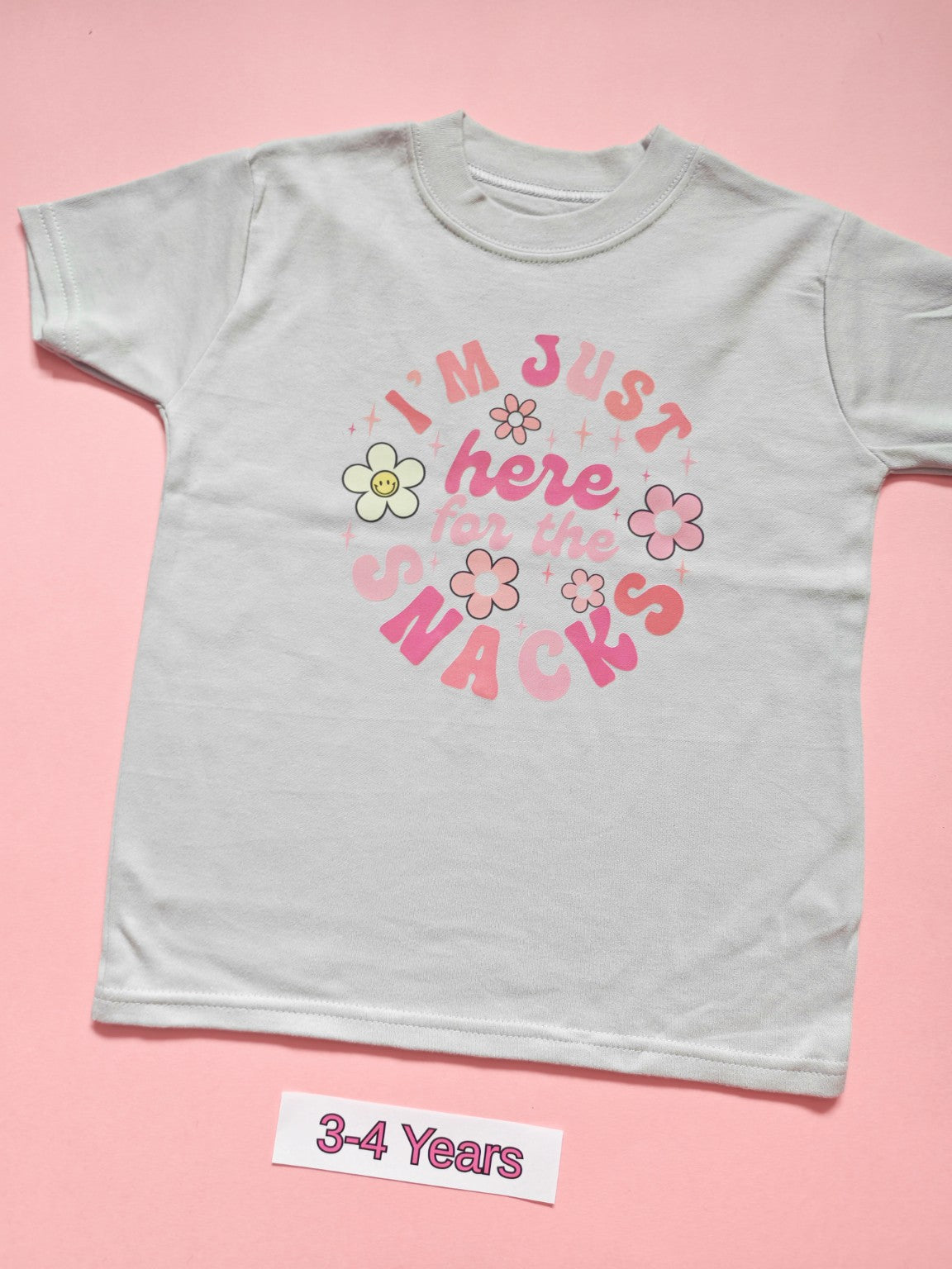 White children's T-shirt with pink I'm Just Here for the Snacks floral design, size 3-4 years