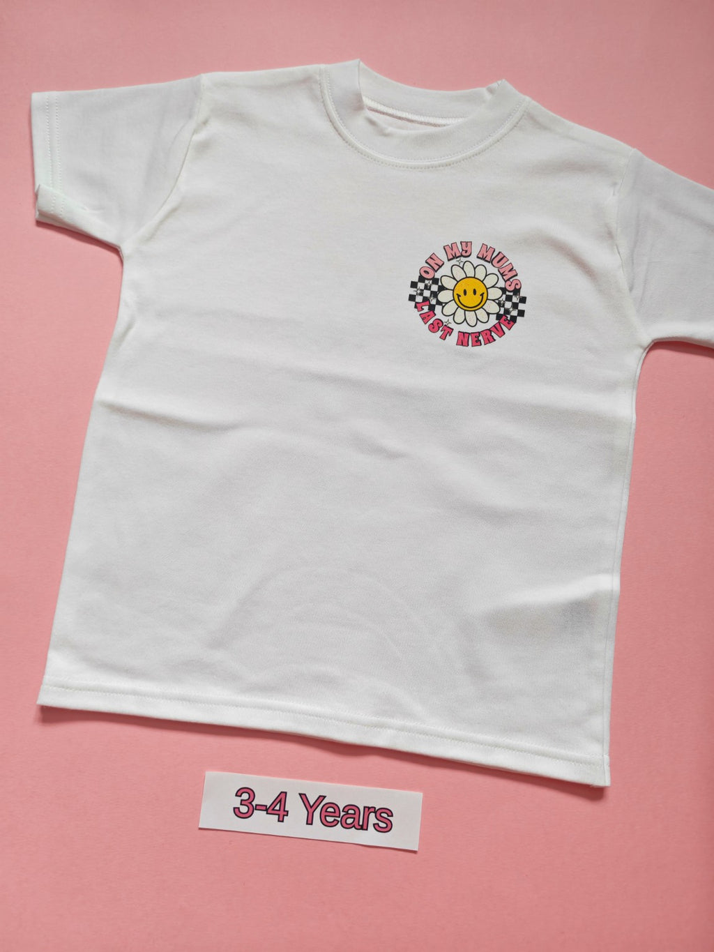 White children's T-shirt with pink daisy and checkerboard On My Mum's Last Nerve design, size 3-4 years