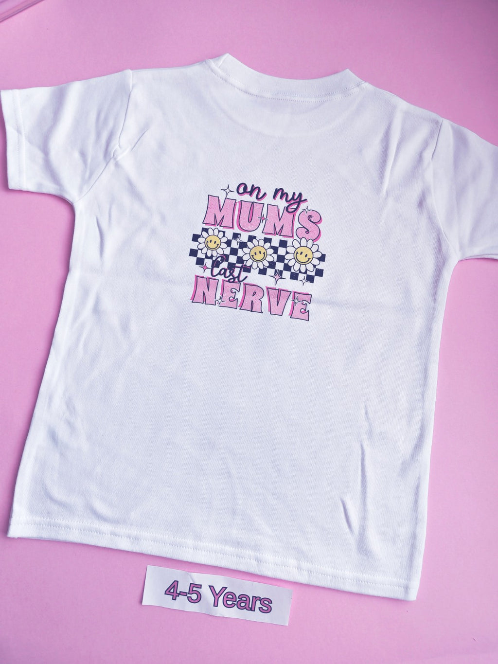 White children's t-shirt with pink On My Mum's Last Nerve daisy and checkerboard design on the back, 4-5 years