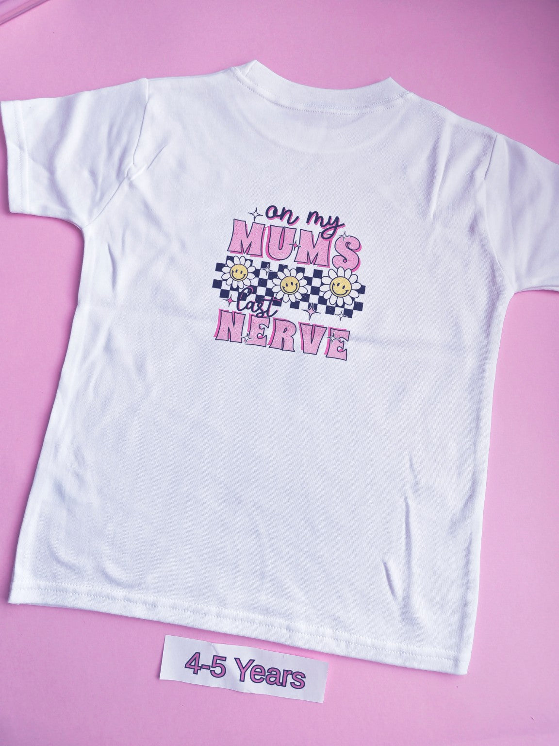 White children's t-shirt with pink On My Mum's Last Nerve daisy and checkerboard design on the back, 4-5 years