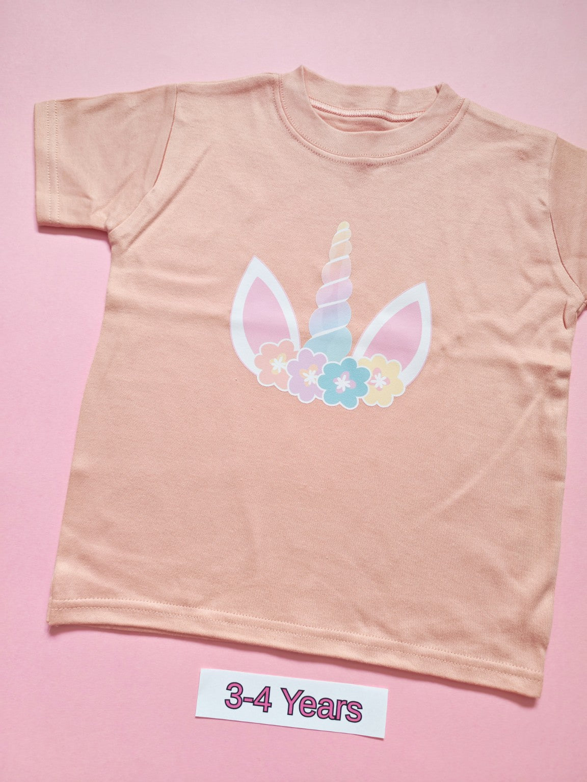 Pastel pink children's T-shirt with pastel unicorn horn, ears and floral design, size 3-4 years