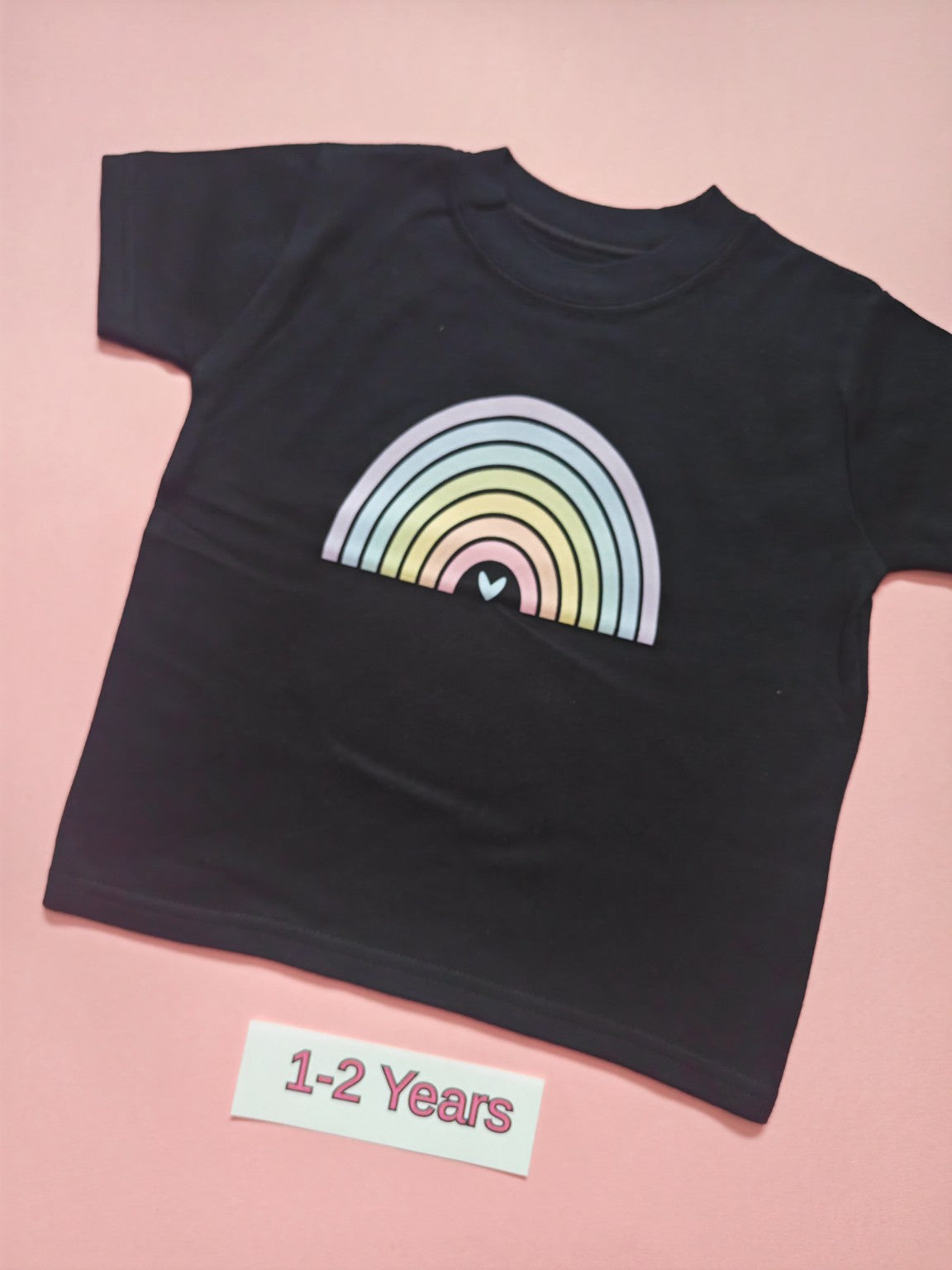 Black children's T-shirt with pastel rainbow design, size 1-2 years