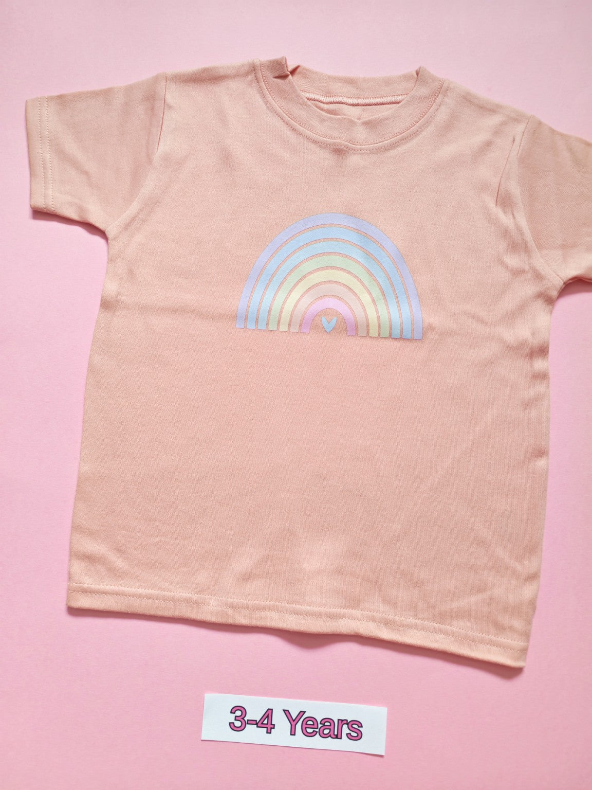 Pastel pink children's T-shirt with soft pastel rainbow design, size 3-4 years