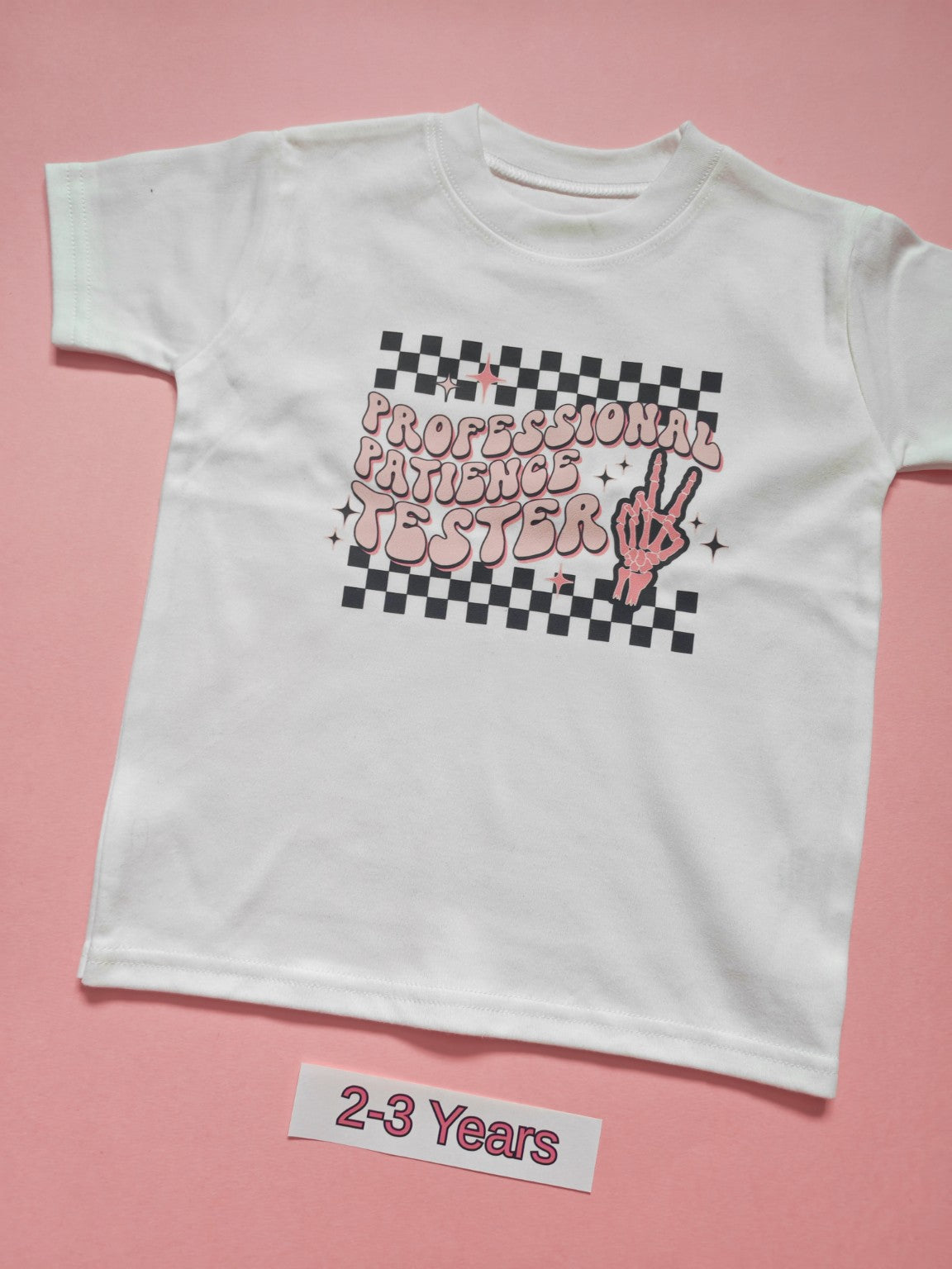 White children's T-shirt with pink Professional Patience Tester design, size 2-3 years