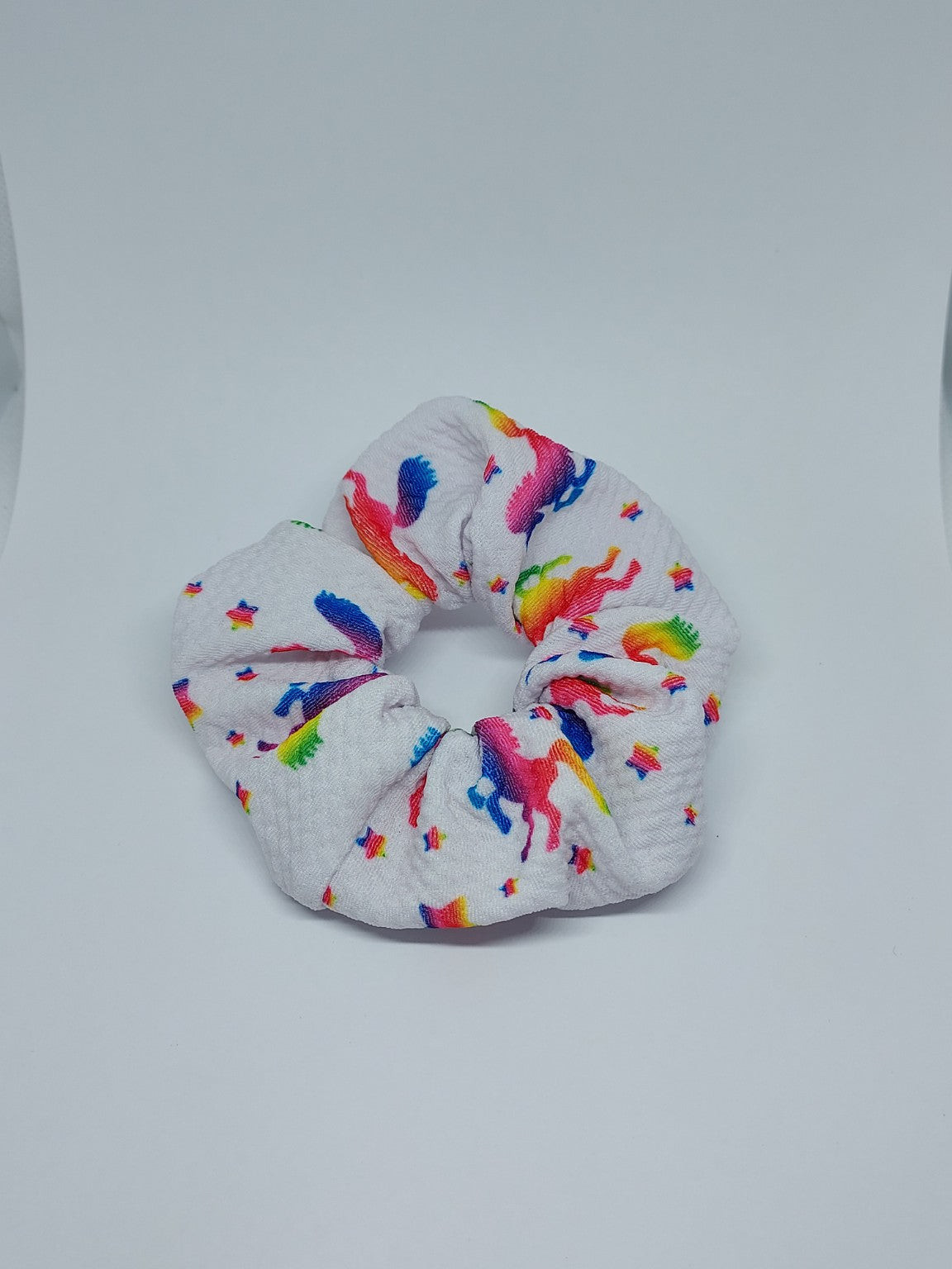 White handmade scrunchie with colourful rainbow unicorn print