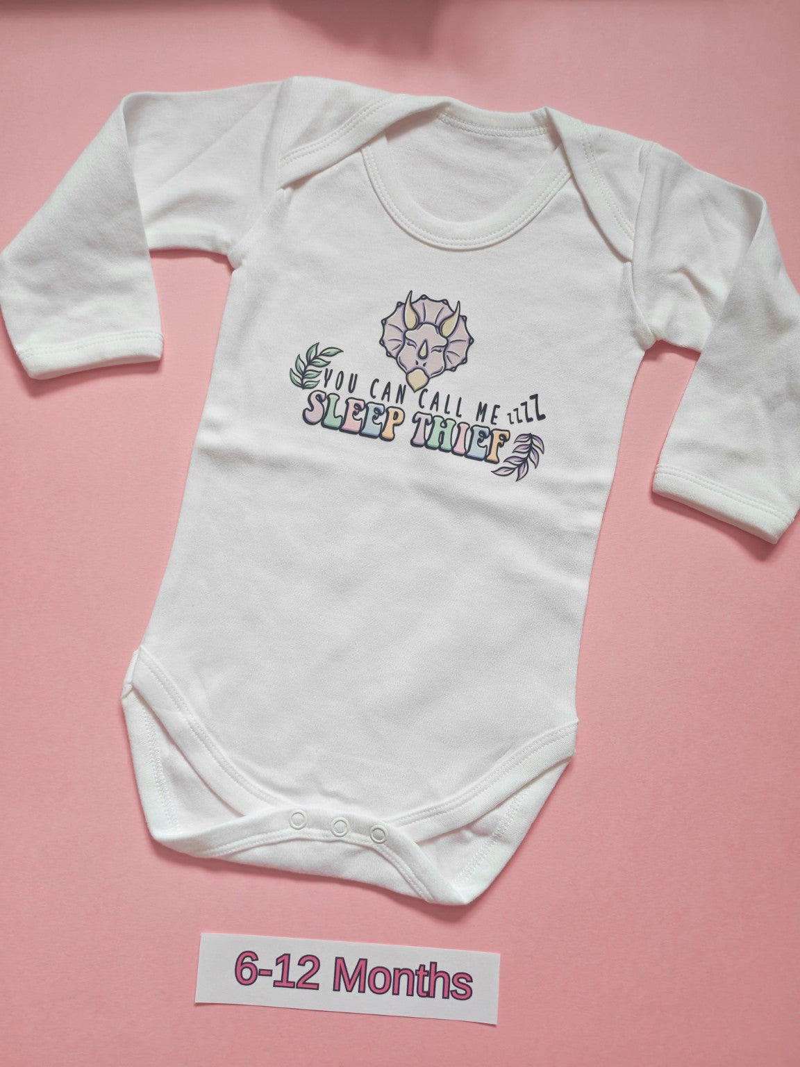 White long sleeve baby bodysuit with colourful dinosaur Sleep Thief design, size 6-12 months