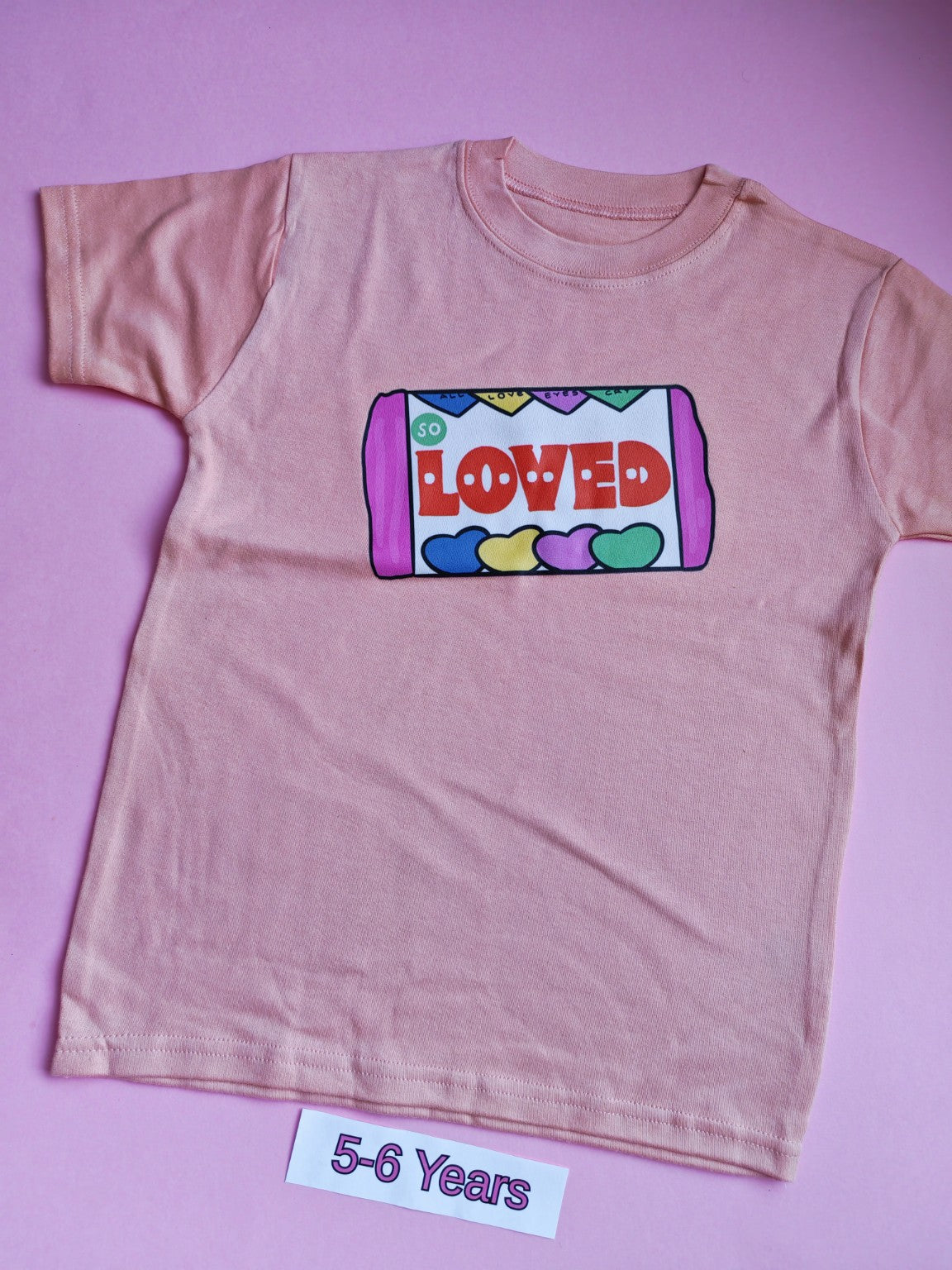 Peach children's t-shirt with colourful So Loved sweets design, 5-6 years